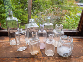 Decorations of the shelf with different bottles without cork in old wooden cottage