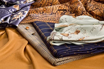 Fotobehang A composition of natural fine fabrics for women's clothing lying on a piece of vicuna fabric © hacohob