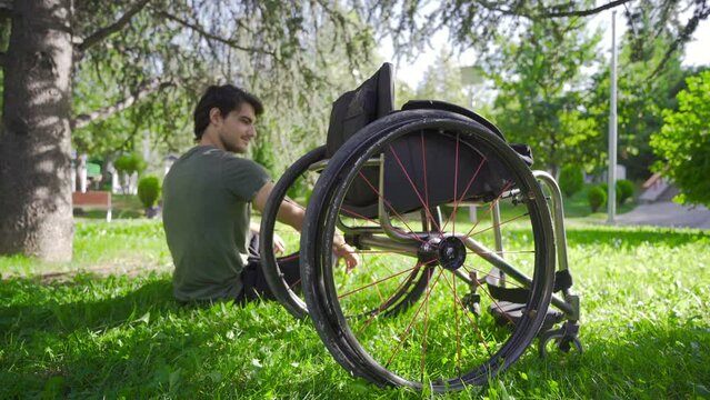 Young disabled person looking at his wheelchair.
Disabled young man lovingly looking at his wheelchair.
