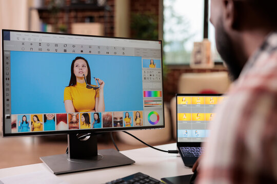 African american editor using retouching software to edit photo, creating professional photography content. Freelancer artist editing image with color grading and retoucher interface.