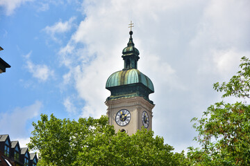 The tower and the roof of the Heiliggeist Church in Munich - obrazy, fototapety, plakaty