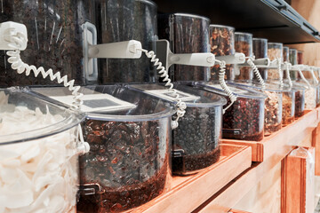 bulk food dispensers display with grains and dried fruits in a store close up