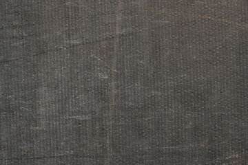 Background of a black awning in close-up. The texture of an old worn tarpaulin. The tent tarpaulin damaged in nature