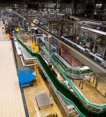 View of empty bottles on conveyor of bottling line at modern brewery..