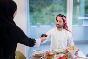 modern multiethnic muslim family sharing a bowl of dates while enjoying iftar dinner together during a ramadan feast at home