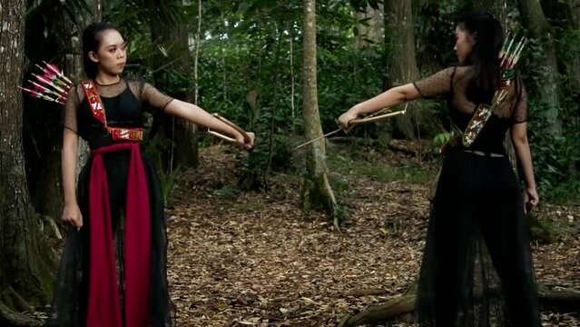 a couple of woman actors aiming the gold bow at each other
