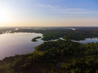 Aerial view of Igapó, the Amazon rainforest in Brazil, an incredible green landscape with lots of water and untouched nature at sunset time