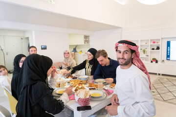 young arabian man having Iftar dinner with muslim family Eating traditional food during Ramadan feasting month at home. The Islamic Halal Eating and Drinking Islamic family