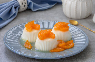 Vanilla panna cotta or jelly custard pudding served on a plate with slices of caramelised...