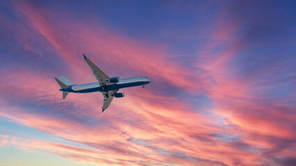 A plane flies into a purple-red sunset. setting sun. Sunset.