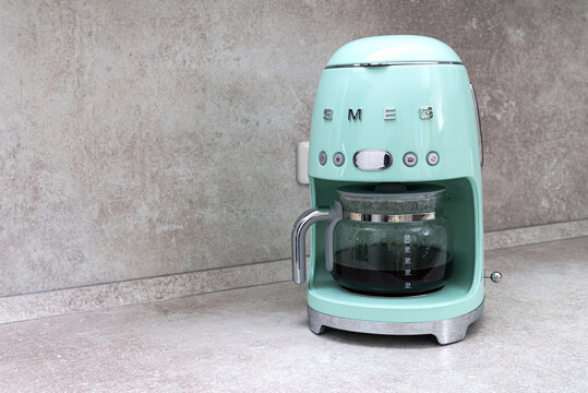 closeup coffee maker SMEG brand. And freshly brewed coffee on the kitchen table.