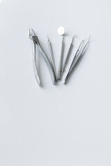 Metal tools of the dentist on a white background. Aesthetics of dentistry. forceps, tweezers, mirror, curettes and scalers