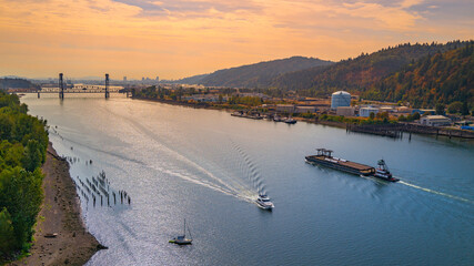 Autumn sunset landscape over Willamette River in Portland, Oregon State, aerial view with cruising boat and ships.