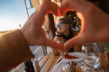 Daughter gesturing heart against mother