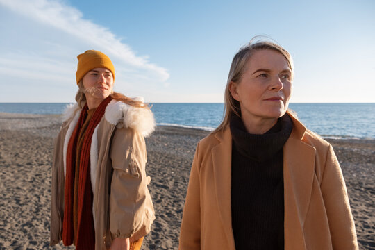Mother and daughter in windy morning on seashore