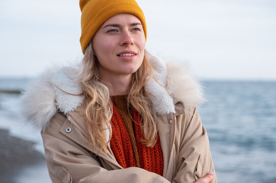 Blond woman on cold day near sea
