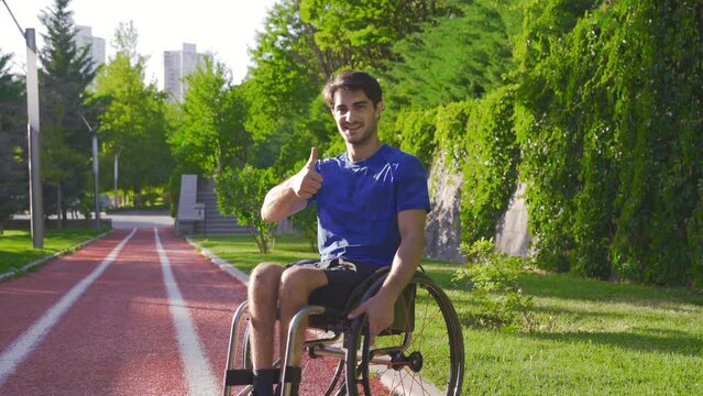 The disabled young man looks at the camera, smiles and says okay.
Athlete amputee teenager is outdoors.
