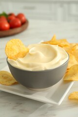 Potato chips and mayonnaise on white marble table