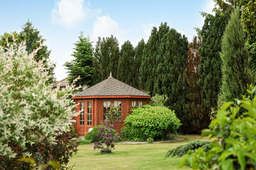 Picturesque view of gazebo in beautiful garden on sunny day