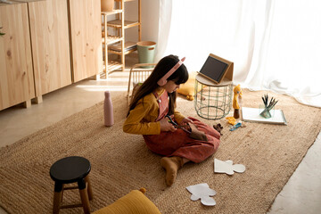 Contemporary girl making handcrafts at home