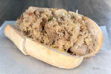 Lunch is served with a loaded bratwurst and sauerkraut sandwich overflowing with ingredients