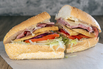Lunch is served with a loaded chicken breast and ham sandwich overflowing with swiss cheese