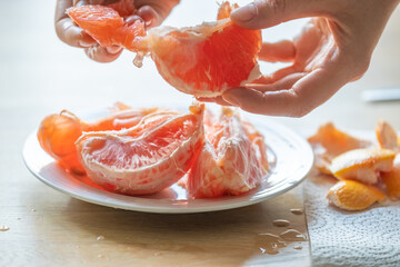 grapefruit.Citrus fruit. hands peeling a grapefruit.Fresh and juicy grapefruit.