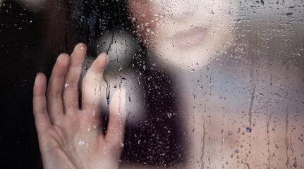 Obraz na płótnie Canvas Girl at the wet window