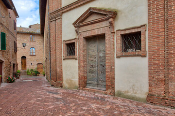 Italy, Tuscany, Pienza. Entrance to an old building along the narrow street of Pienza.
