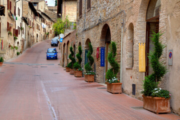 Italy, Tuscany, San Gimignano. Homes decorated with flower pots along the streets of San Gimignano.