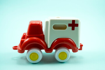 red paint plastic toy ambulance car isolated on turquoise