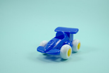 Blue paint plastic toy racing car with number three isolated on turquoise