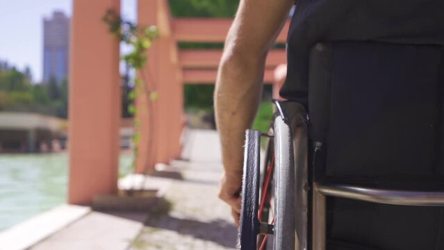 He rotates the wheelchair in slow motion.
Close-up of disabled young man using wheelchair in slow motion.
