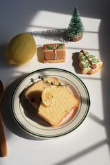 Homemade Lemon cake decorated with christmas tree cookie for party under sunlight. Tasty dessert for winter holidays. Merry Christmas and Happy New Year atmosphere. Light and shadow.