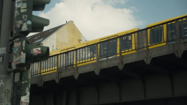 Yellow U-Bahn Train Passing over an Industrial Bridge in Berlin, Germany. Half Speed Slow Motion in 4K.