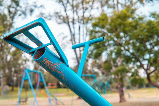 High quality photography. Blue Seesaw in the park in the empty park without children. Games for children in the park full of grass and nature.