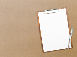 Blank white paper on wooden clipboard with pen on brown card board paper box background, business and education concept