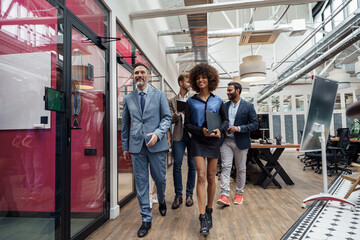 Group of multiethnic business people crossing office together