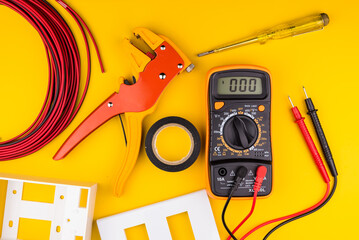Different electrician's supplies on yellow background. Background of professional electrician tools with space for text.electrician concept home electrical repair technician. - 532326569