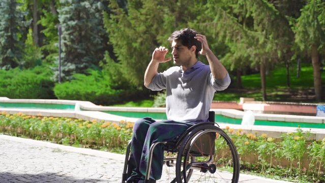 Disabled young man driving his wheelchair in slow motion.
Disabled young man in wheelchair outdoors in slow motion.
