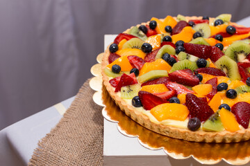 Detalle de tarta de frutilla, durazno, kiwi y arándanos