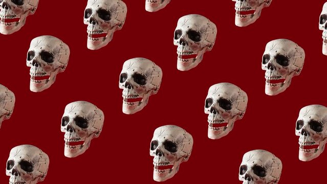 Skulls go up and down on a blood colored background, Halloween pattern, in loop, video animation