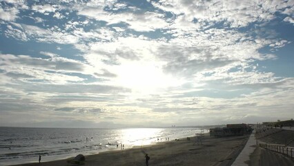 FUJISAWA, KANAGAWA, JAPAN - AUGUST 2022 : View of Enoshima beach (sea) at Shonan area in sunset. Romantic, moody sky in dusk. Japanese hot summer holiday (vacation) season concept video.