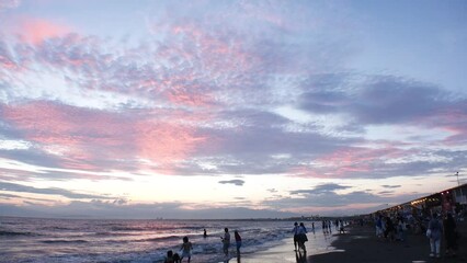 FUJISAWA, KANAGAWA, JAPAN - AUGUST 2022 : View of Enoshima beach (sea) at Shonan area in sunset. Romantic, moody sky in dusk. Japanese hot summer holiday (vacation) season concept video.