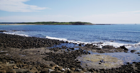 Fototapeta na wymiar Stone rock sea beach with sunny sky