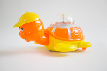 Children's toy orange turtle with disco lights isolated on white