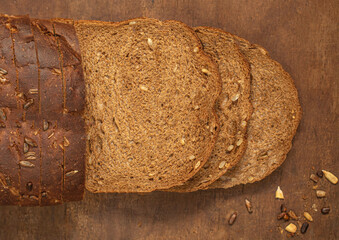 Top view of sliced wholegrain bread on dark ructic wooden background closeup. Top view.