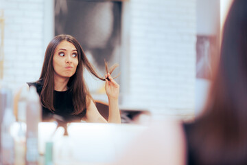 Stressed Woman Looking at her Slip Ends in Hair Salon. Concerned lady in need of hair treatment in...