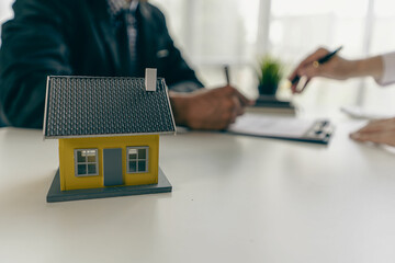Home agents talk to new home buyers and offer good interest rates and calculate clients on mortgage financing to help make real estate concept decisions.