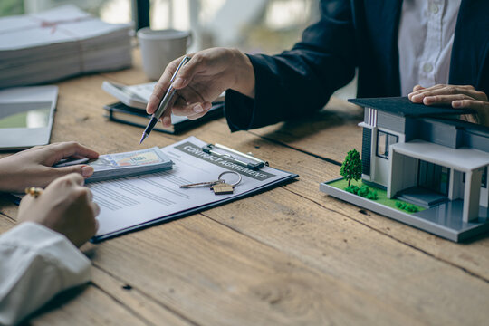 Home agents talk to new home buyers and offer good interest rates and calculate clients on mortgage financing to help make real estate concept decisions.